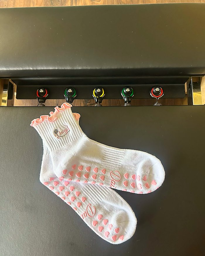Pink Blossom Pilates grip socks worn in a reformer studio