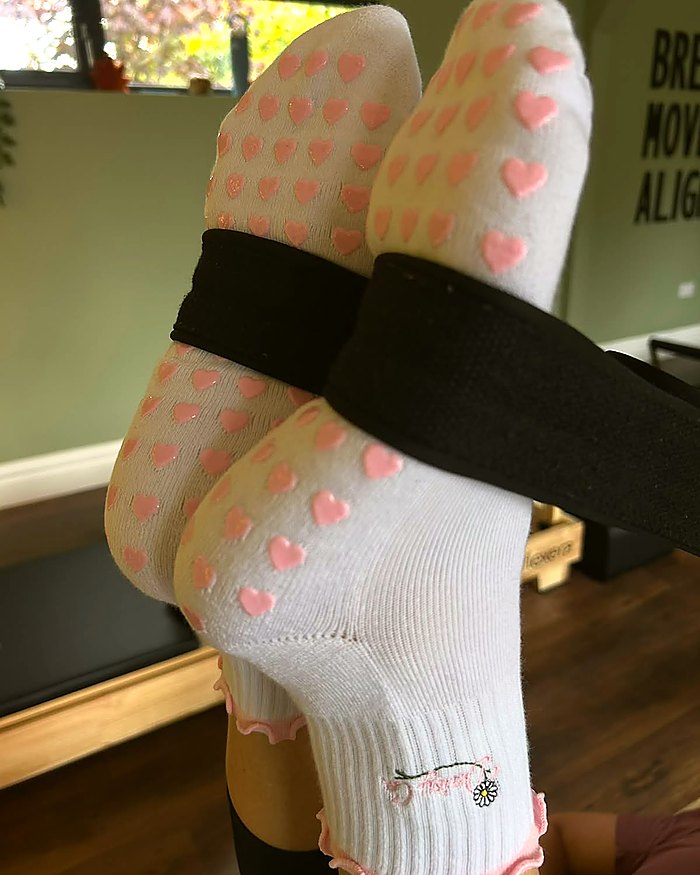 Pink Blossom Pilates grip socks during a reformer class