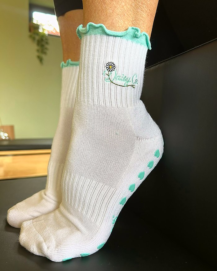 Sea Mist Pilates grip socks worn in a reformer studio