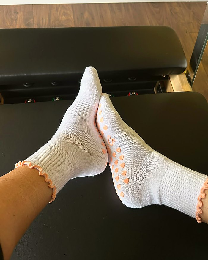 Bare Muse Pilates grip socks worn in a reformer studio