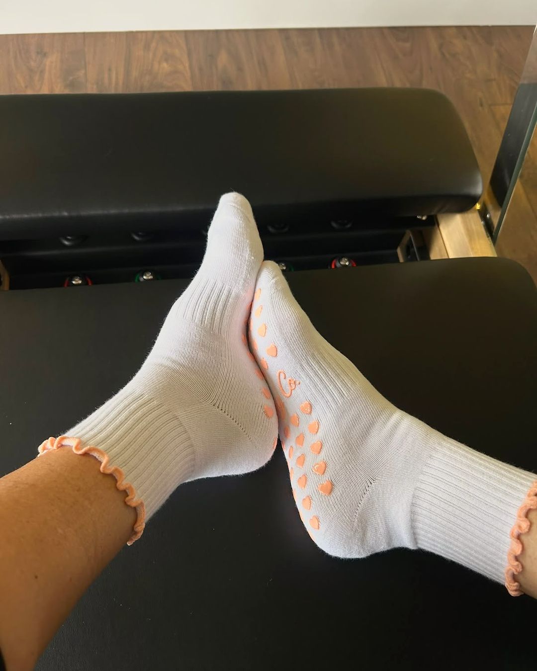 Bare Muse grip socks with both feet on a reformer